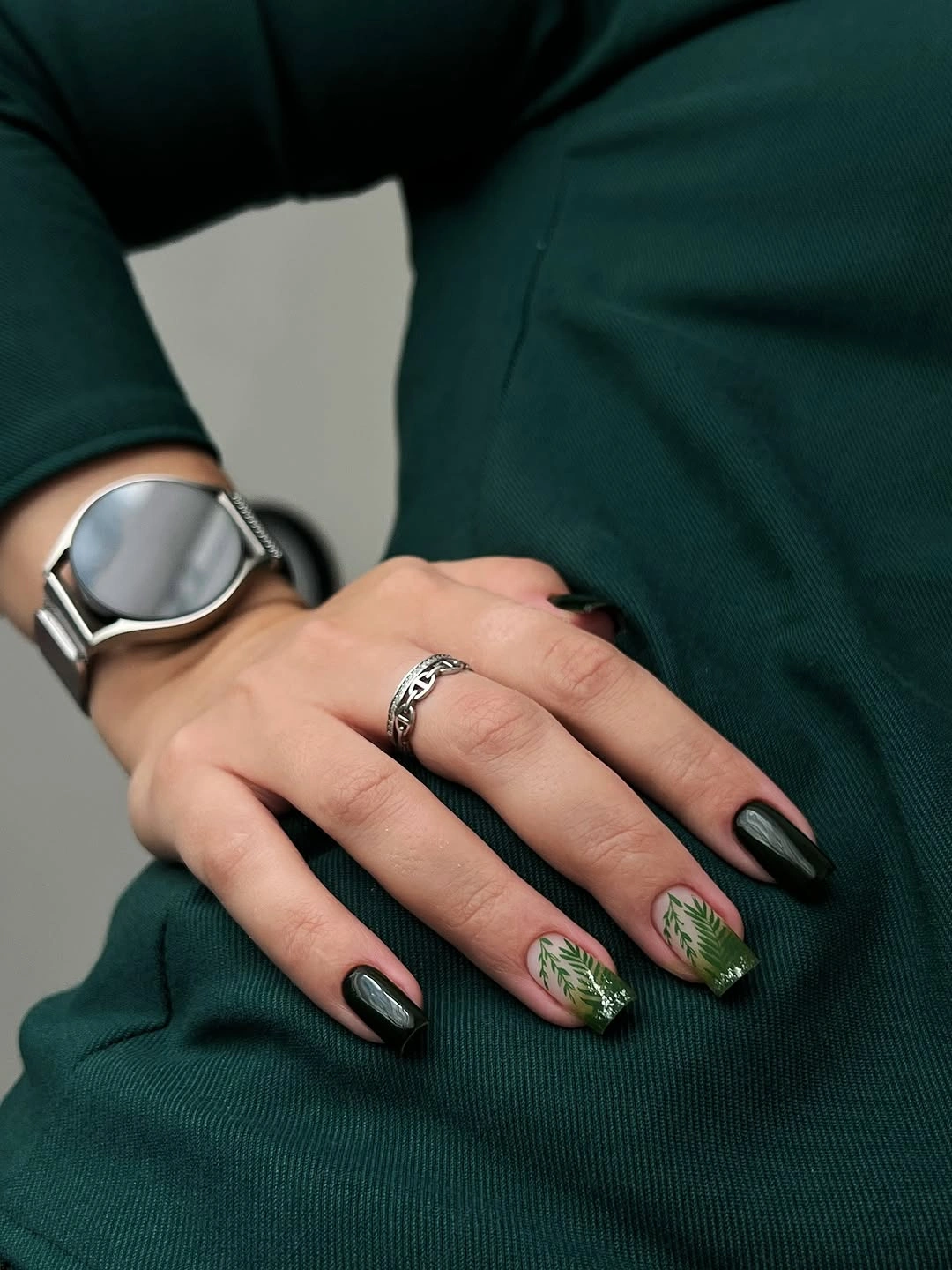 Short rounded black nails with green accents