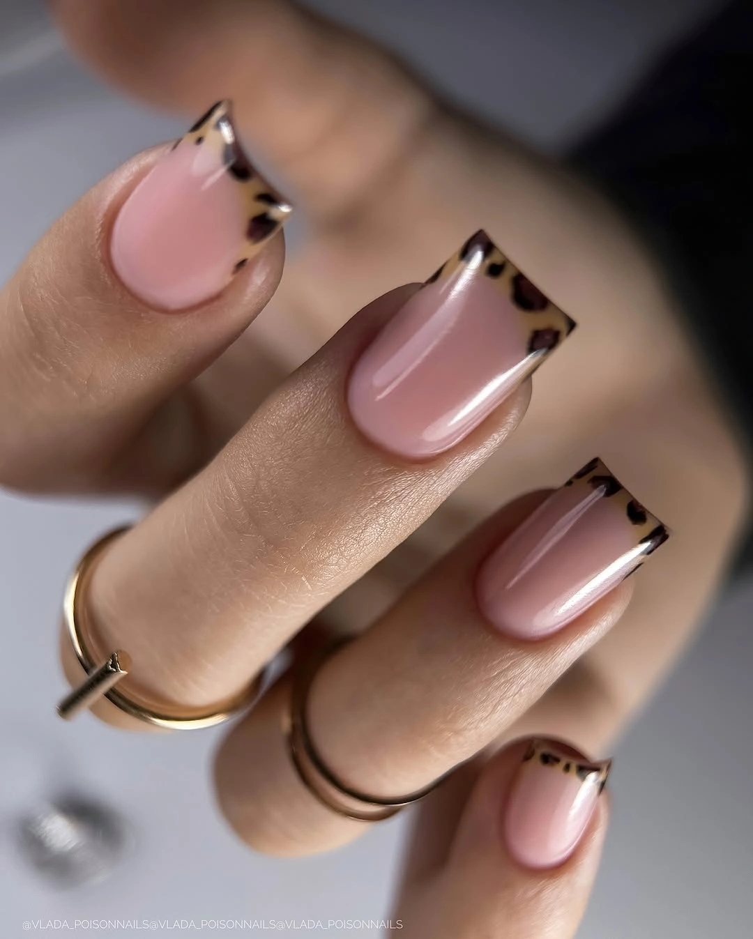 pink nails with black and gold outlined French corners