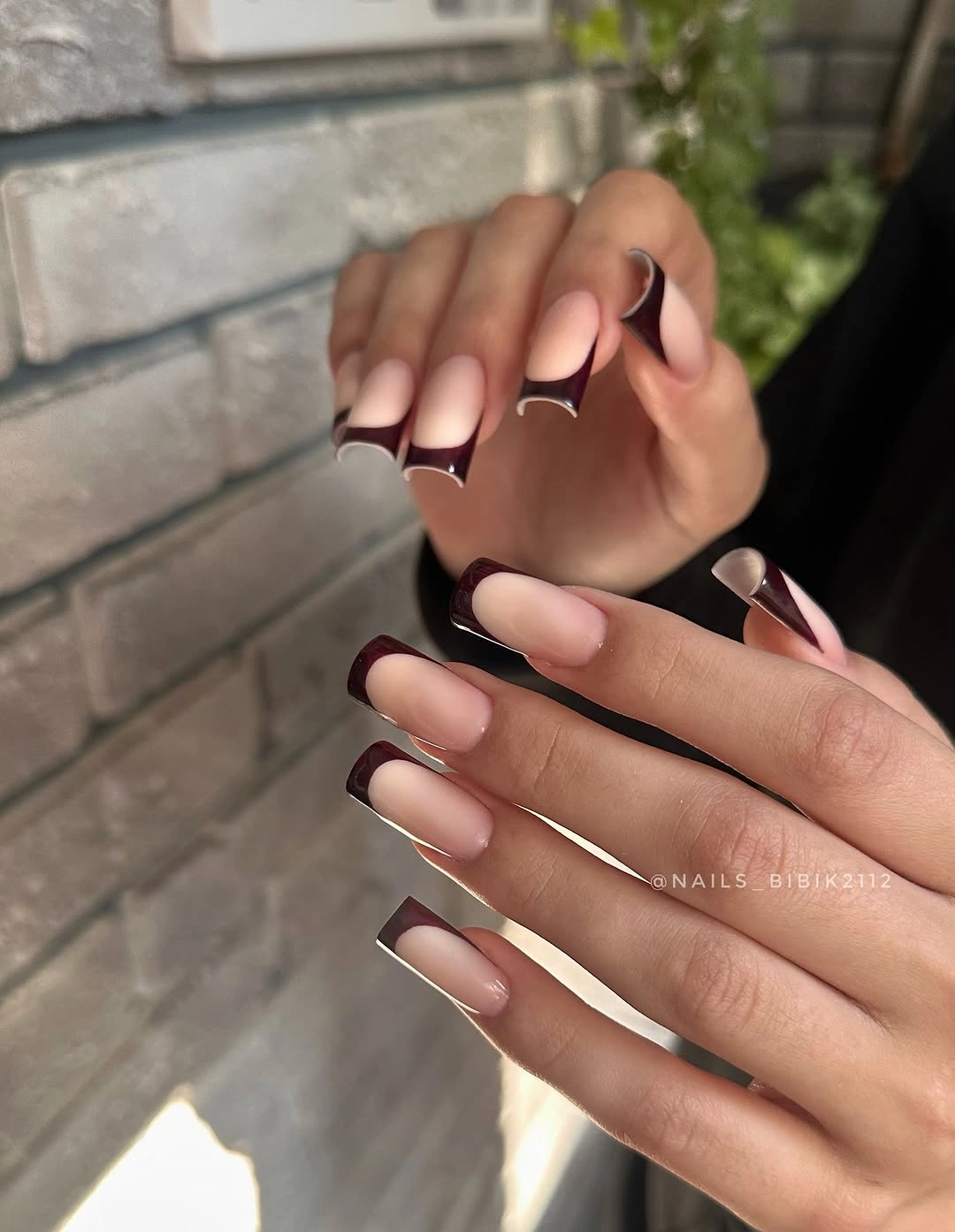 long pale pink almond nails with dark burgundy angled tips