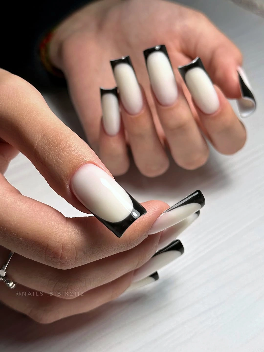 long white square nails edged with bold black French tips