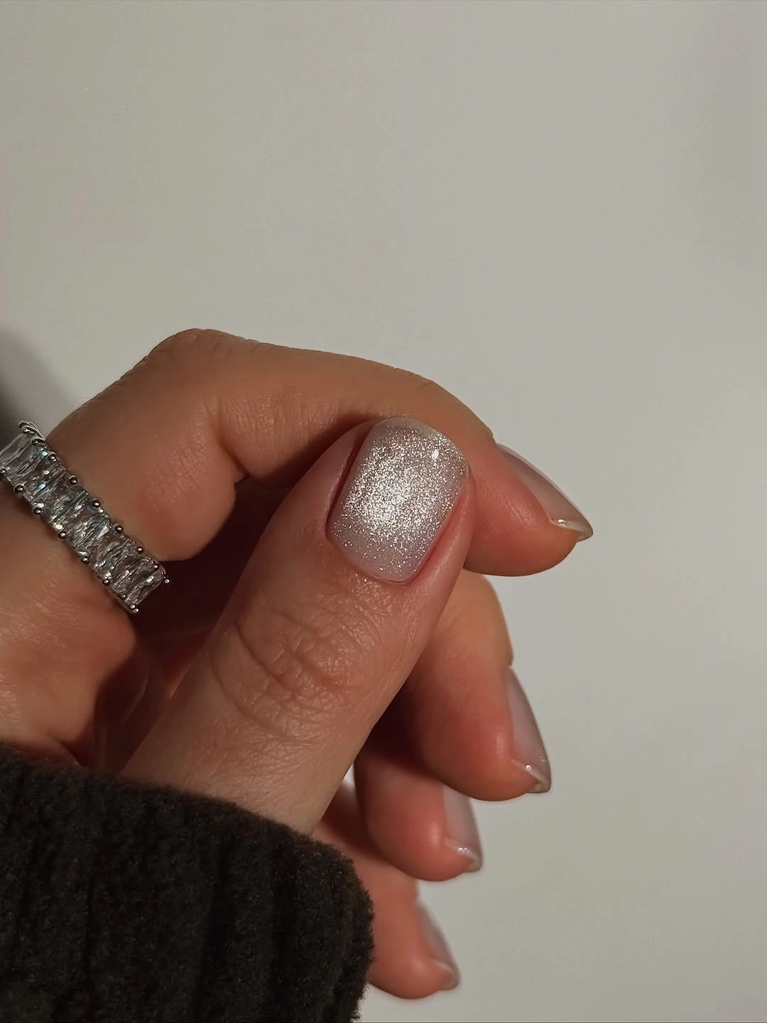 Short pale pink nails with soft silver shimmer