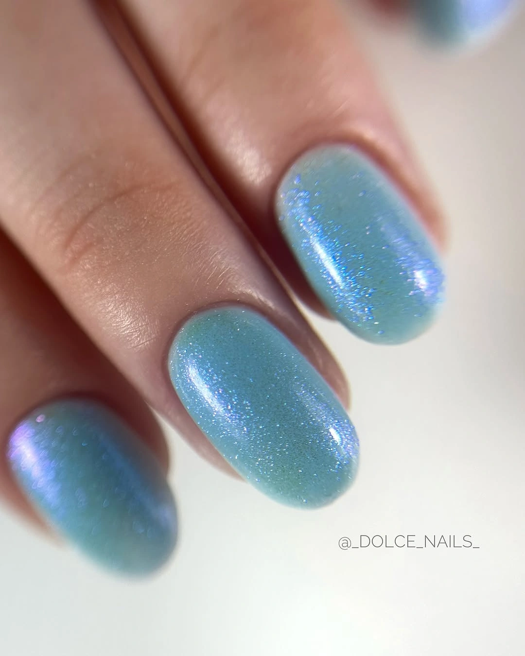 Short icy blue nails with a soft pearly reflective shift