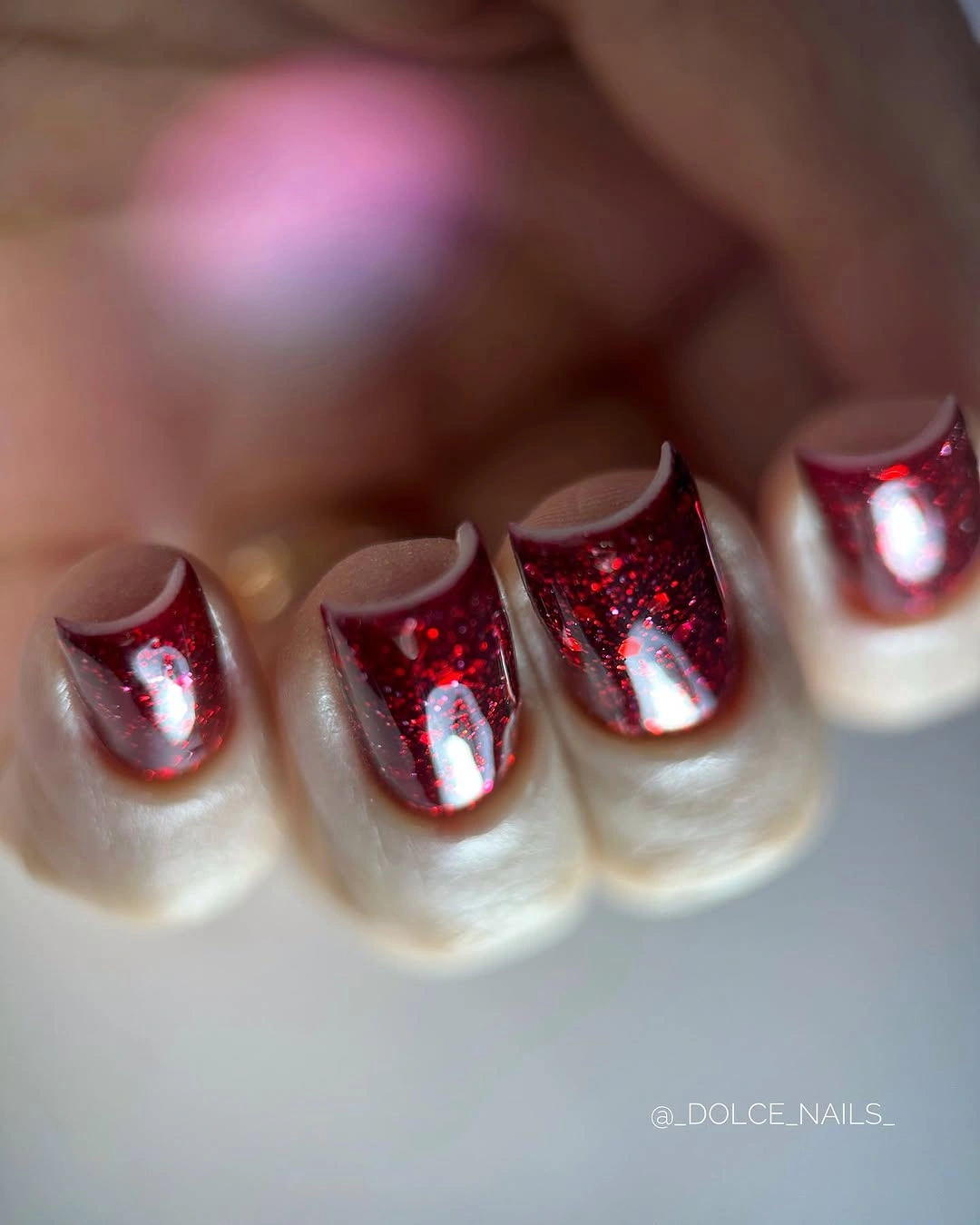 Short pale nails with bright red glitter tips