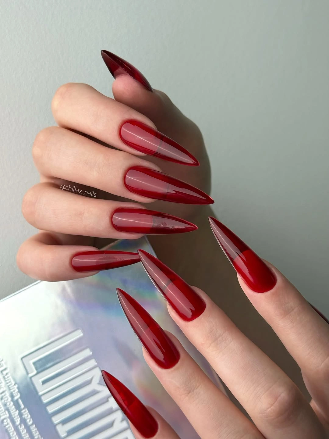 Very long glossy red stiletto nails with solid color