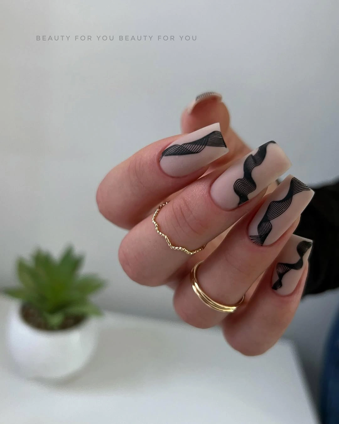 Long almond nude nails with black and white abstract waves
