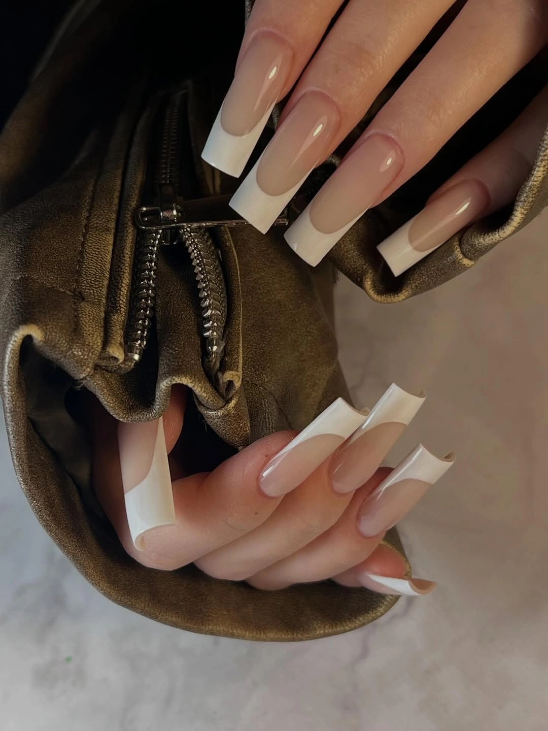 Long square nude nails with broad white French tips