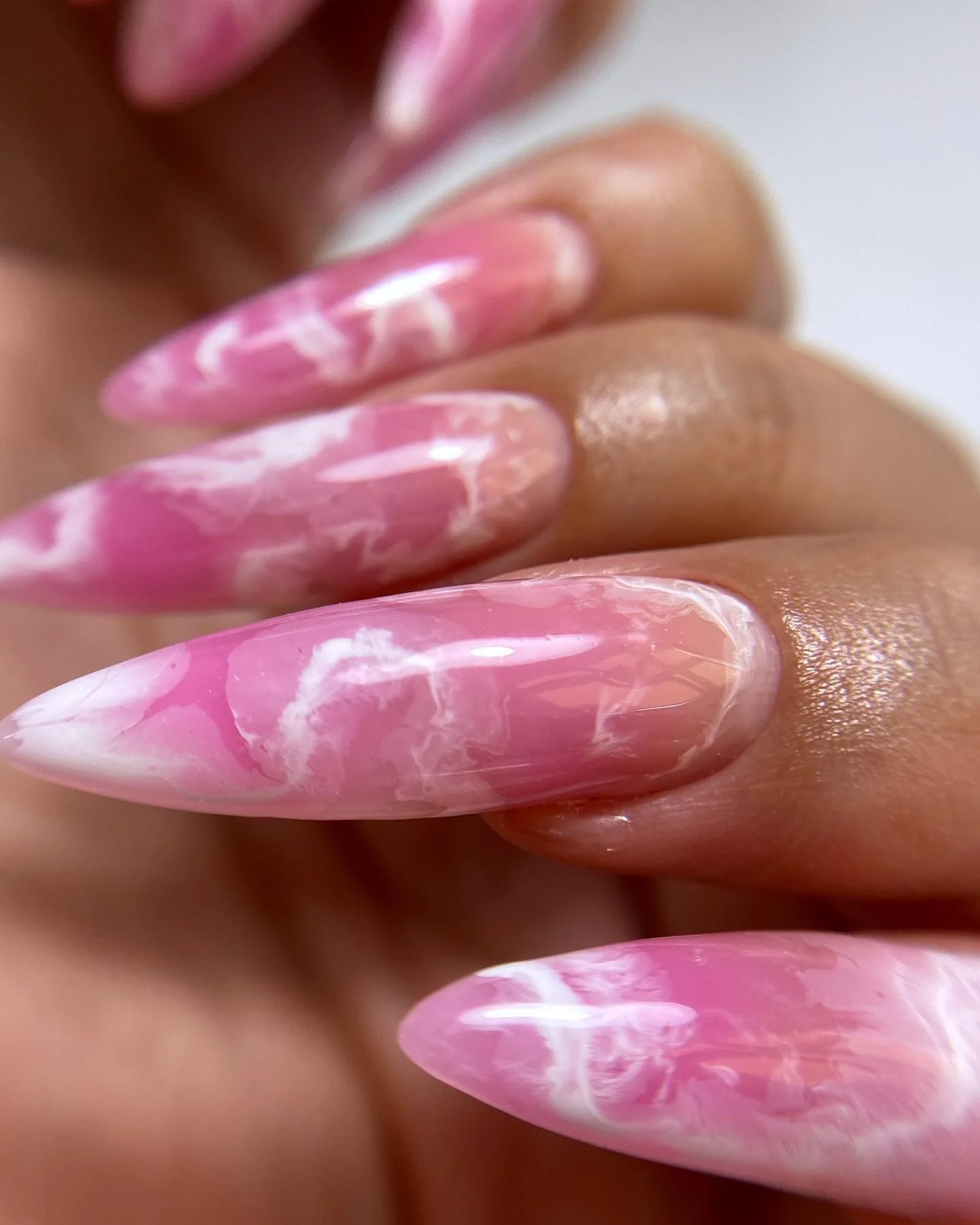 Long pink almond nails with cloudy white marble veining