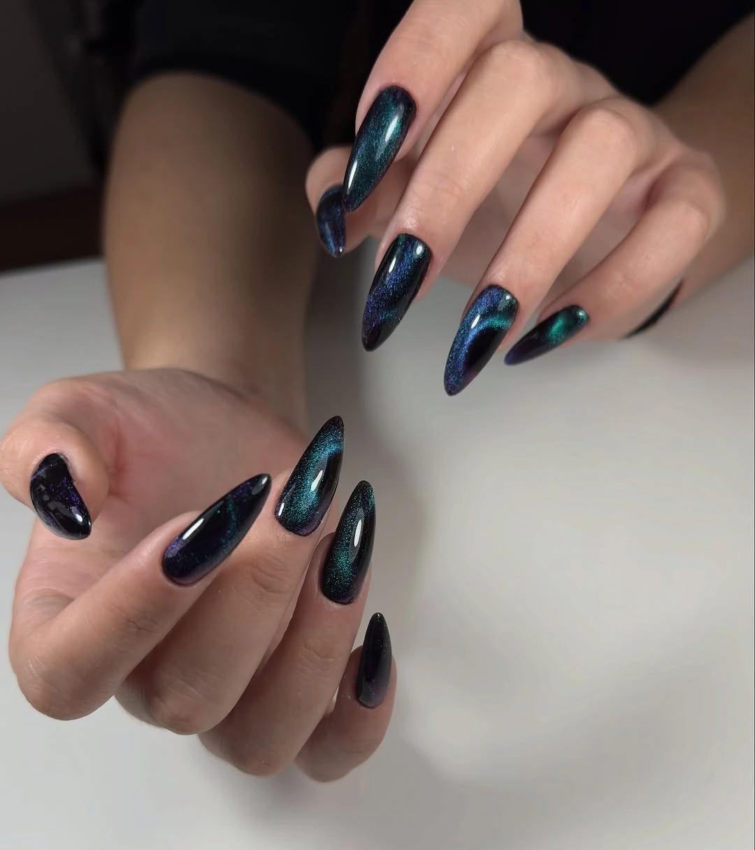 Long blue black almond nails with reflective depth