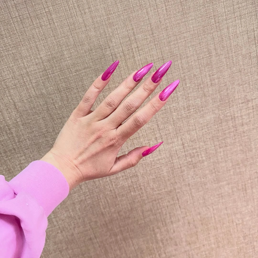 Very long hot pink stiletto nails with solid glossy color
