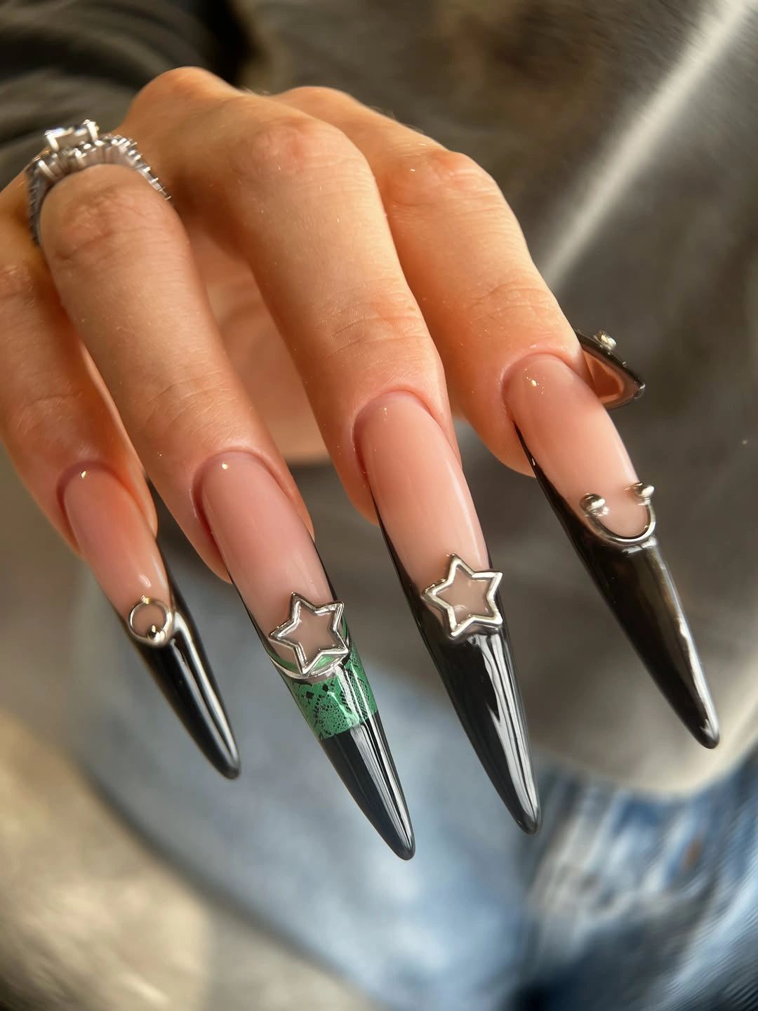 Long pointed nude nails with black silver tips and stars