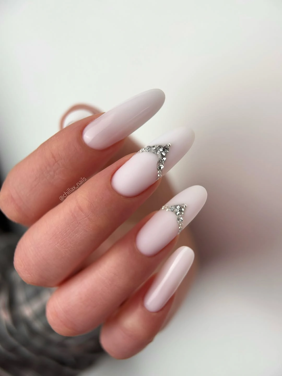 Pale pink almond nails with small silver cuticle accents