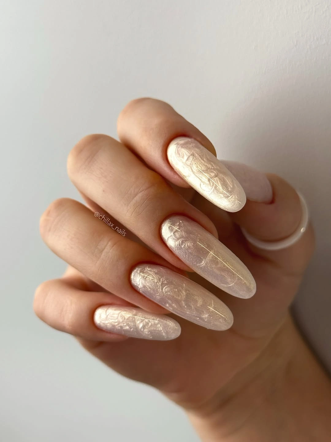 Long ivory almond nails with pale raised botanical details