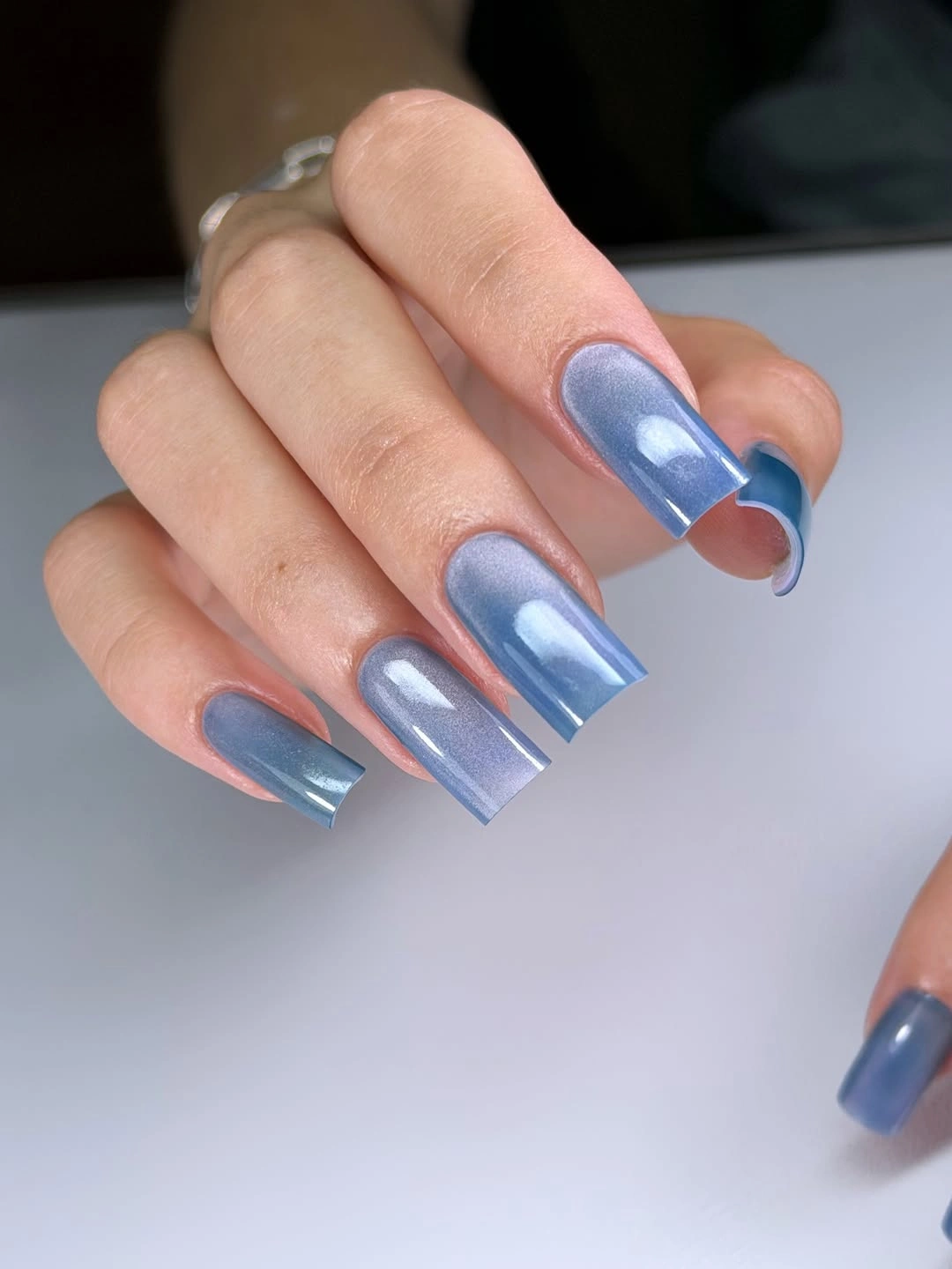 Icy blue reflective square nails with pale translucent tips