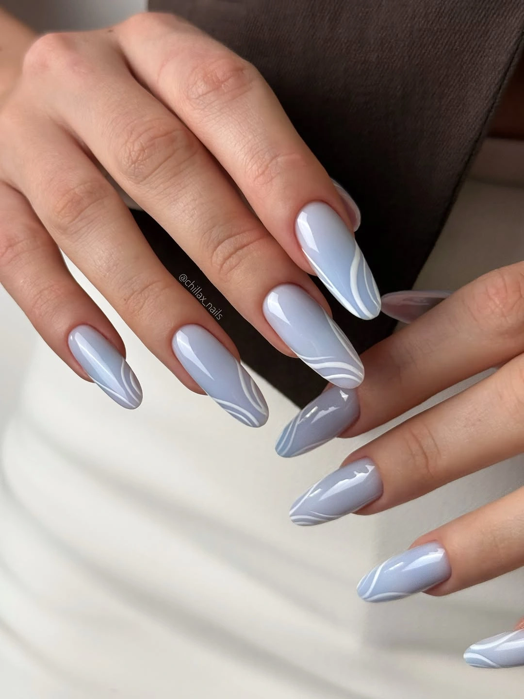 Pale blue gray almond nails with white flowing lines
