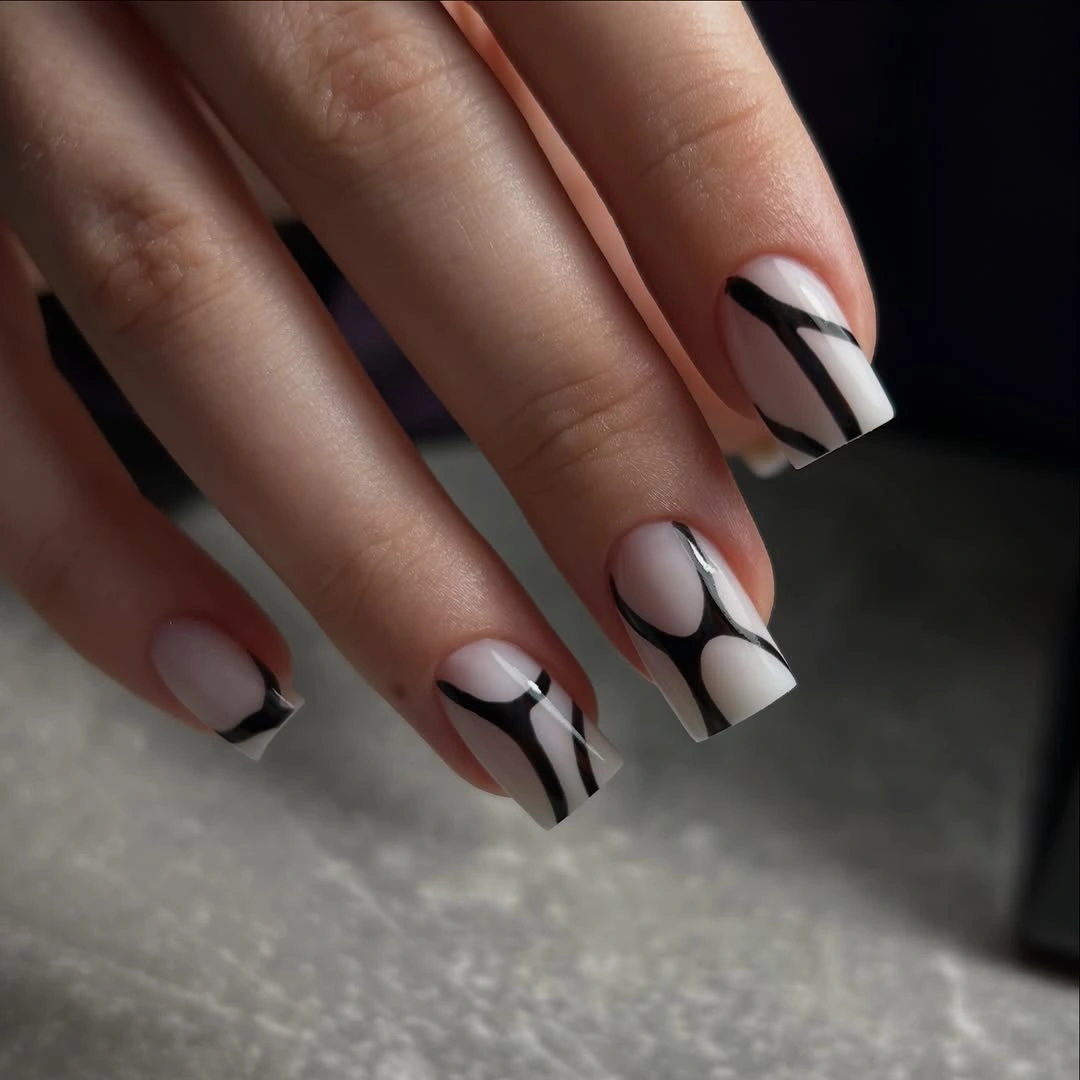 Pale square nails with black curved graphic stripes