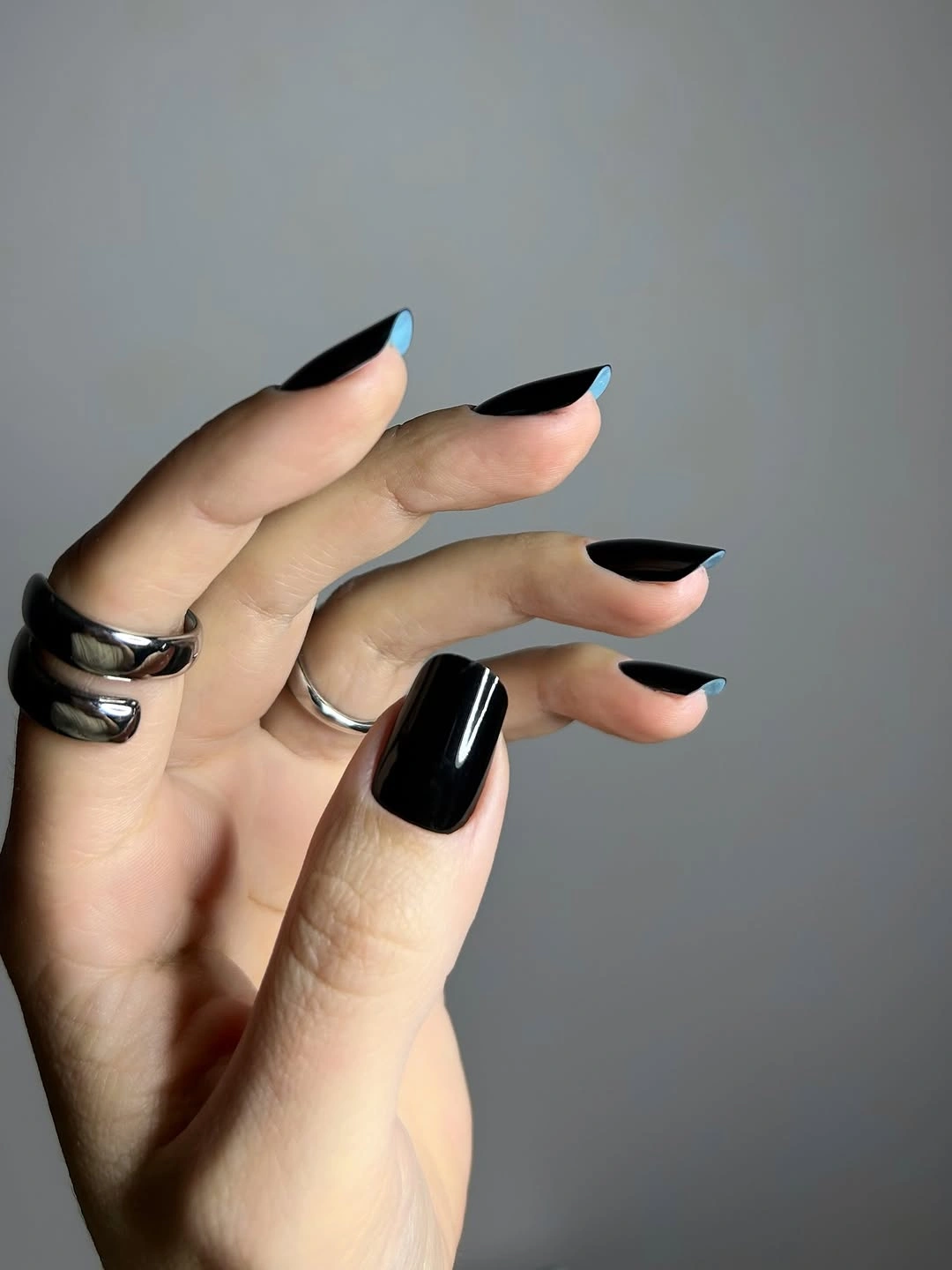 Long pointed nails coated in glossy black polish