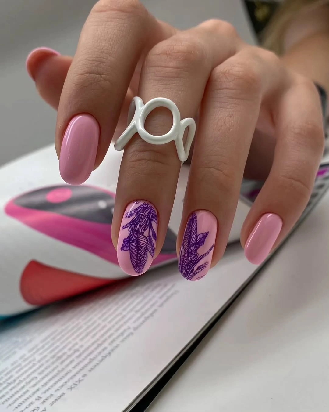 Blush almond nails with loose purple abstract accents