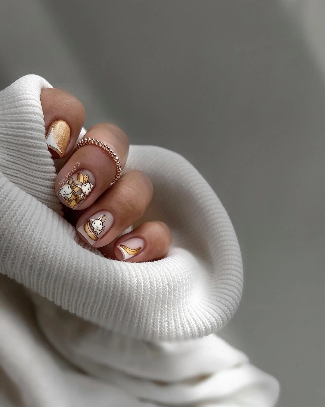 Muted mauve almond nails with gold and pearl accents