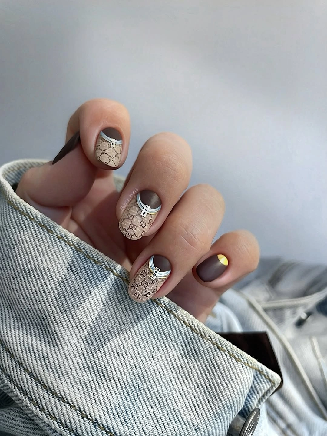 Short neutral nails with pale shapes and fine dark accents