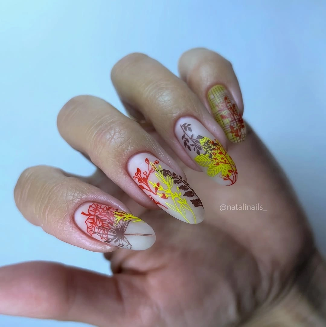 Long almond nails with pale botanical and plaid accents