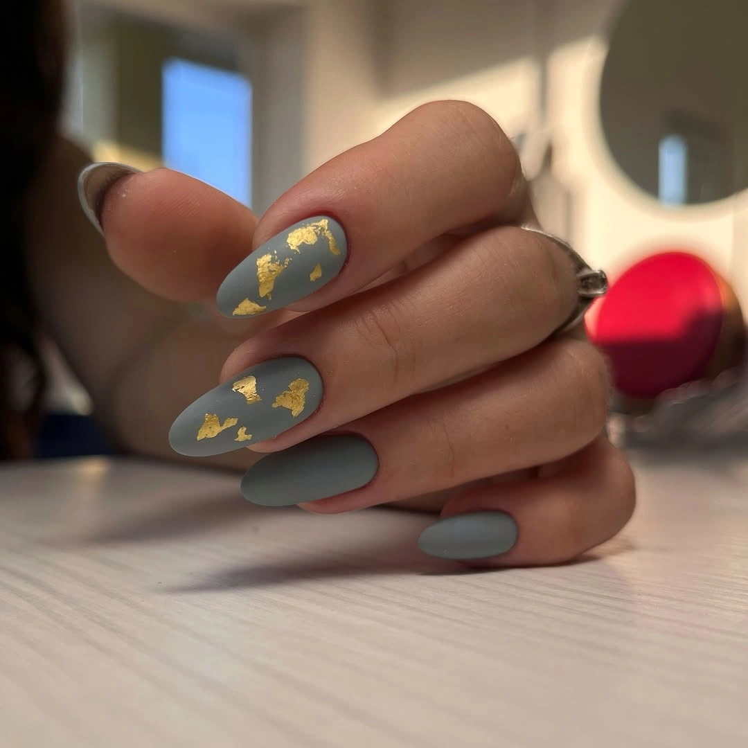 Muted blue gray almond nails with scattered gold foil