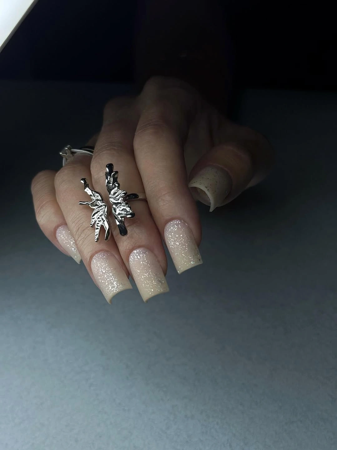 Long square nude nails with a fine pale shimmer