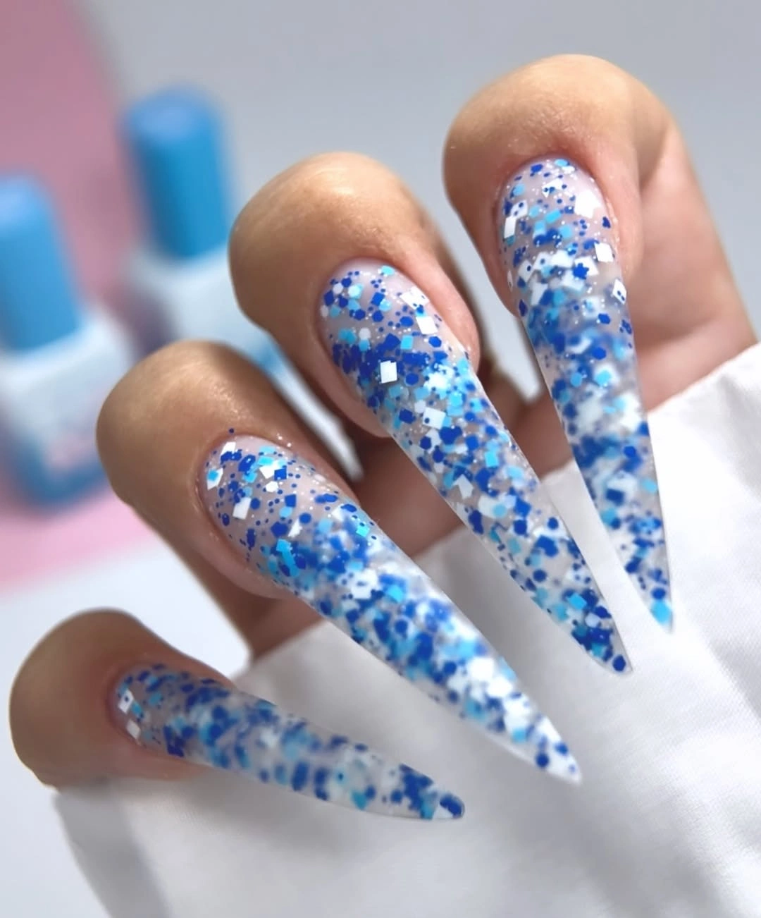 Very long clear stiletto nails with blue white glitter