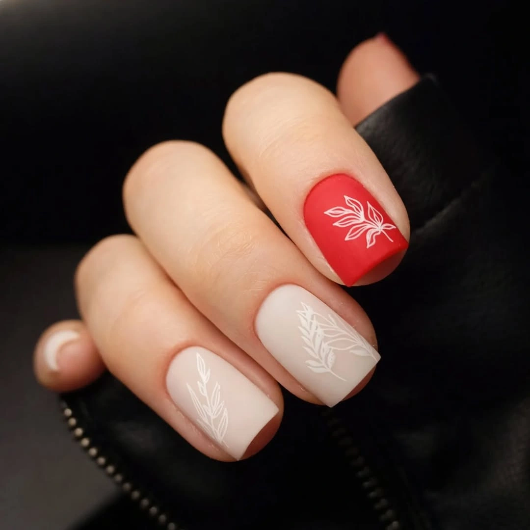 Short square red and nude nails with white leaf art
