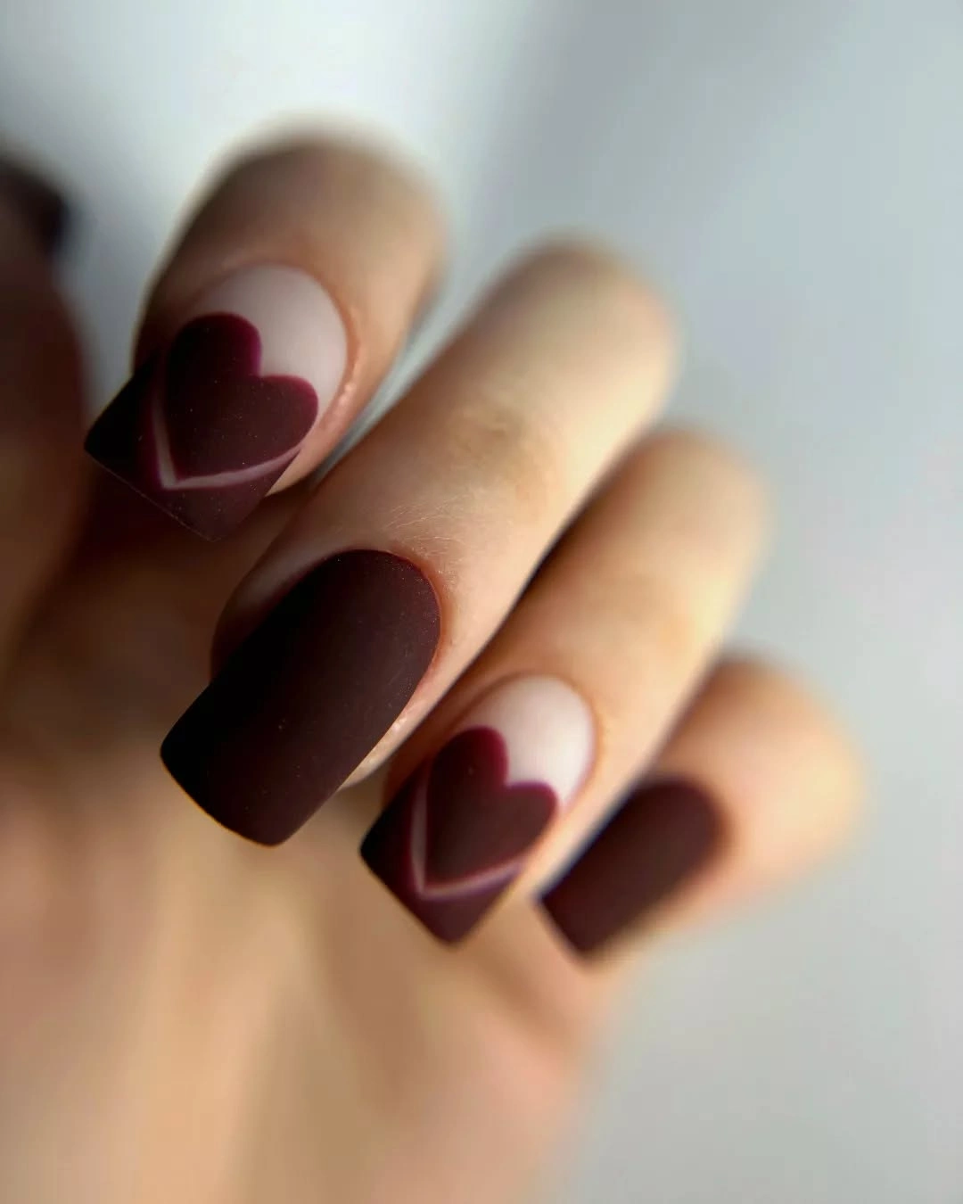 Long coffin nails with deep brown heart shaped French tips