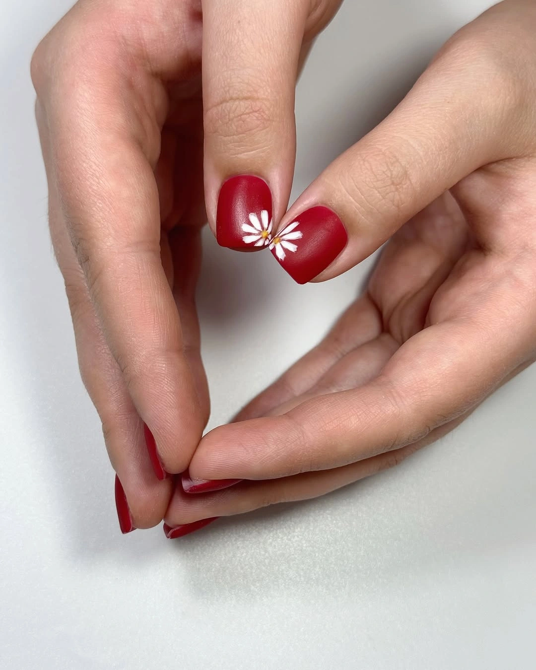 Medium square glossy red nails with one white flower accent