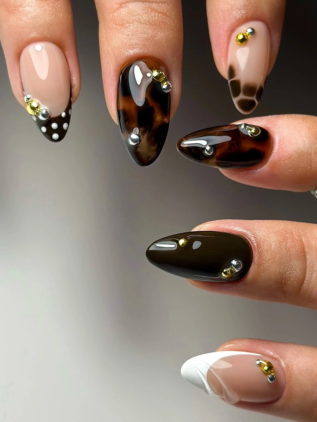 Brown black almond nails with pale sections and gold details