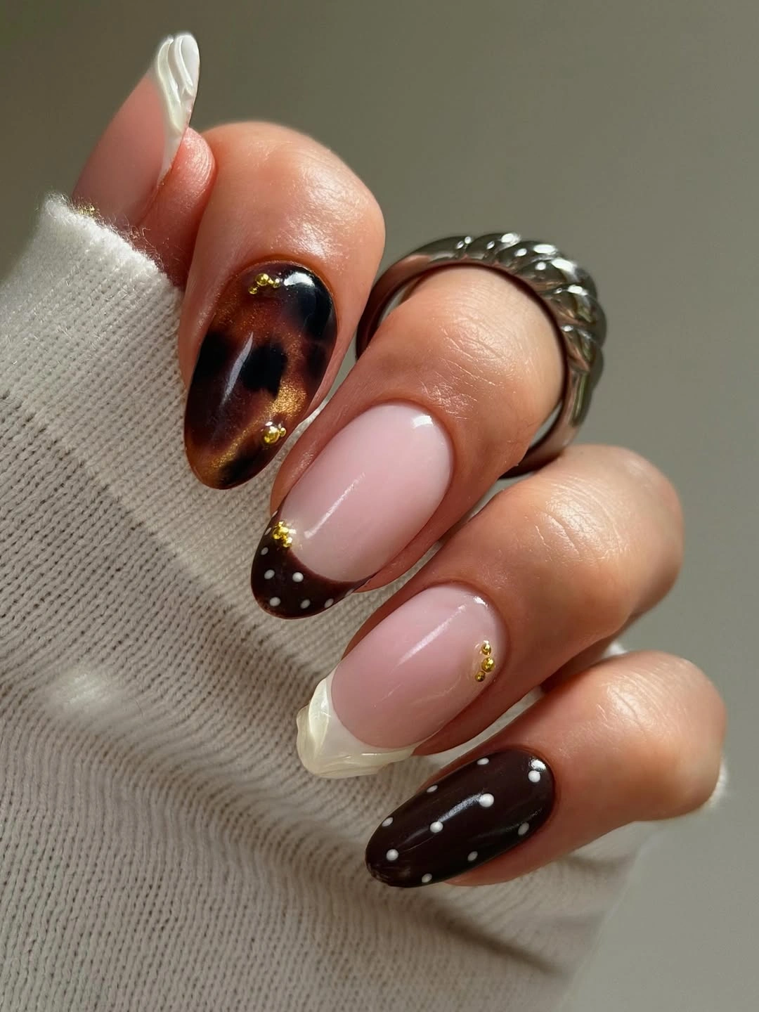 Soft pink and brown oval nails with gold stud accents
