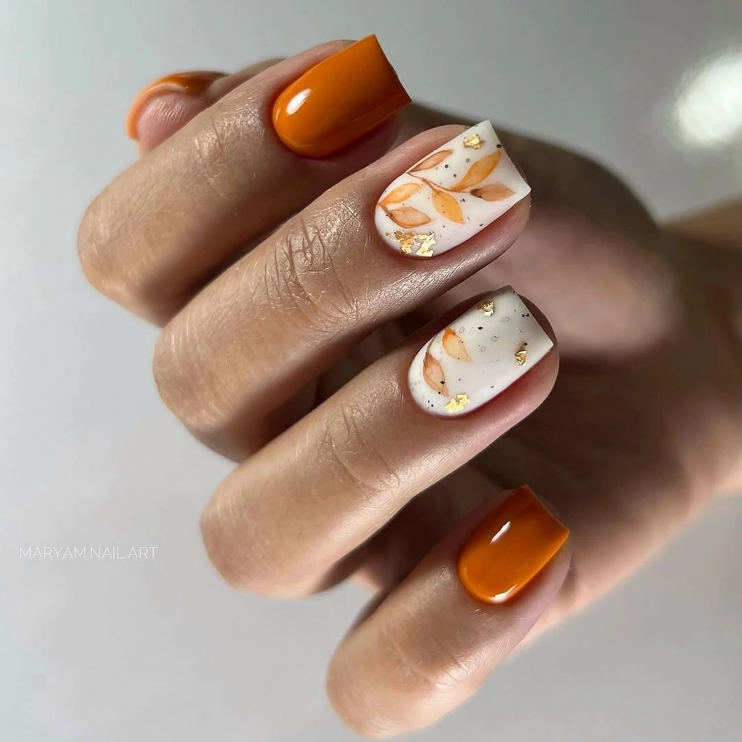Orange square nails with white seasonal accent artwork