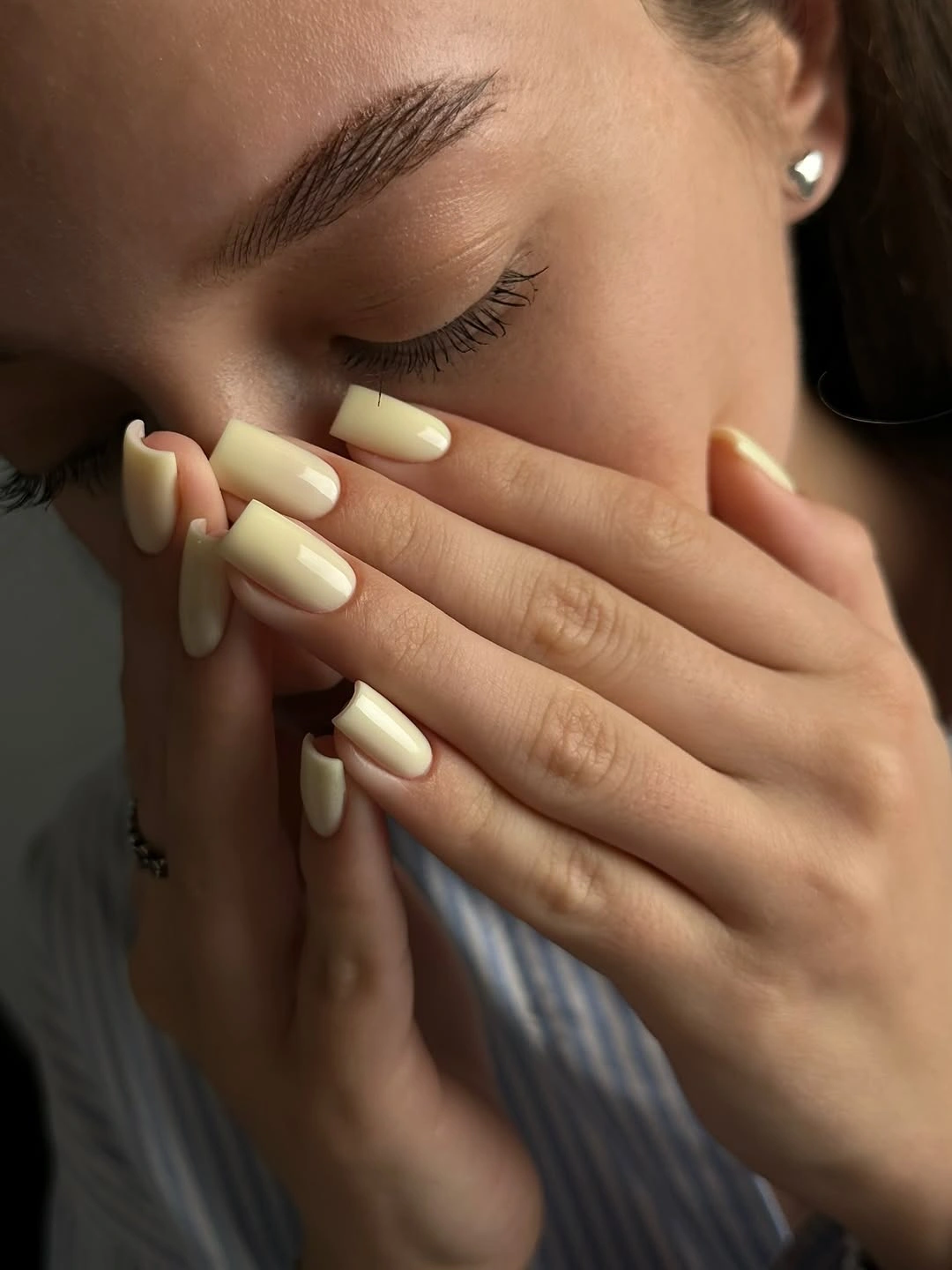 Pale buttery cream rounded nails in a glossy medium length