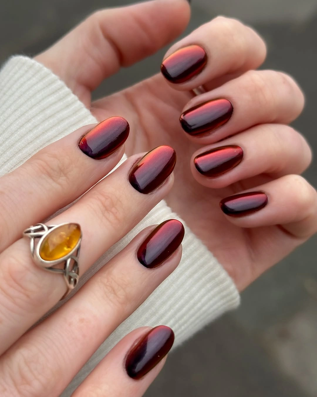 Reflective burgundy rounded nails with red purple highlights