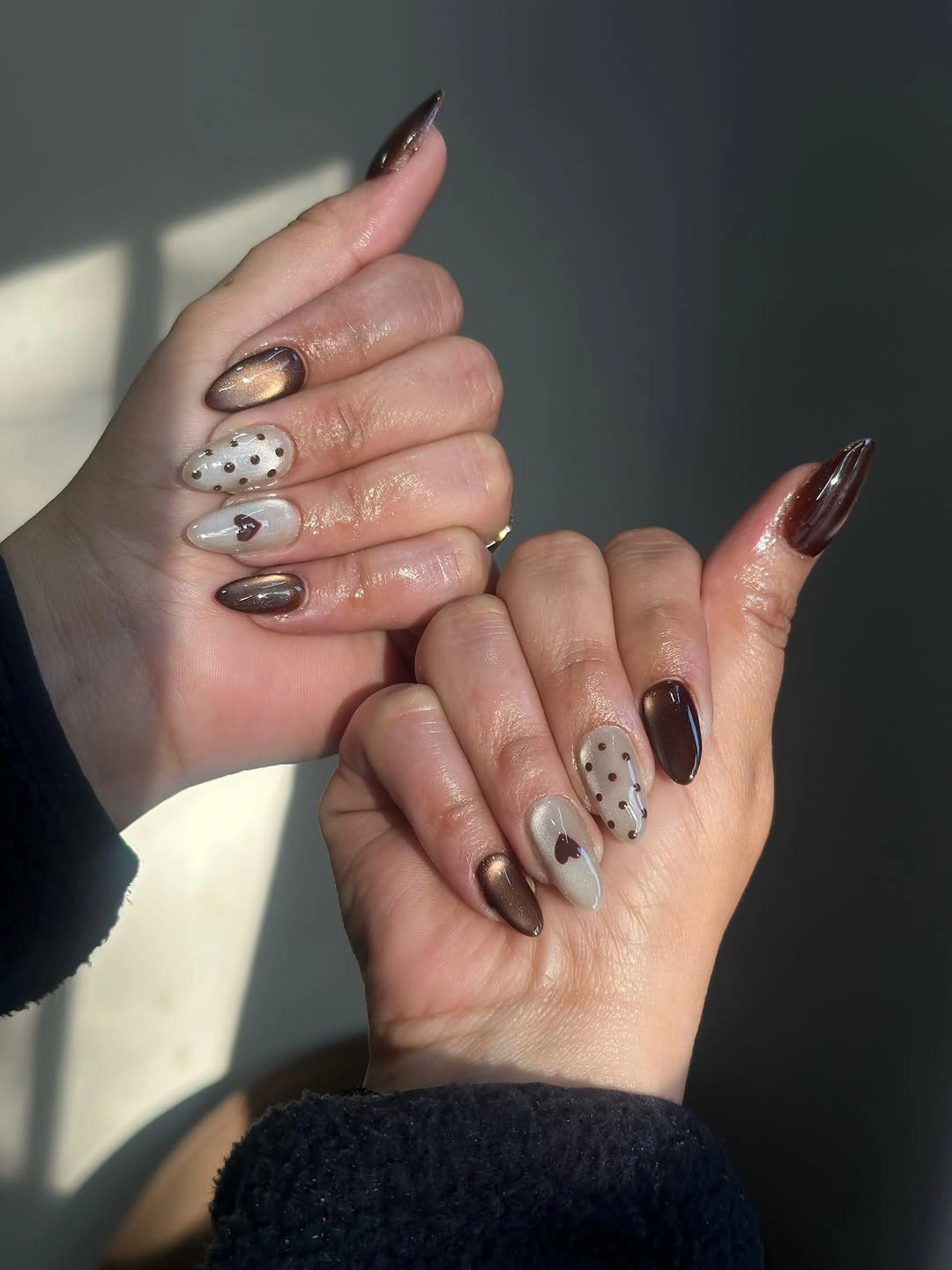 Mixed taupe brown and cream almond nails with reflective accents