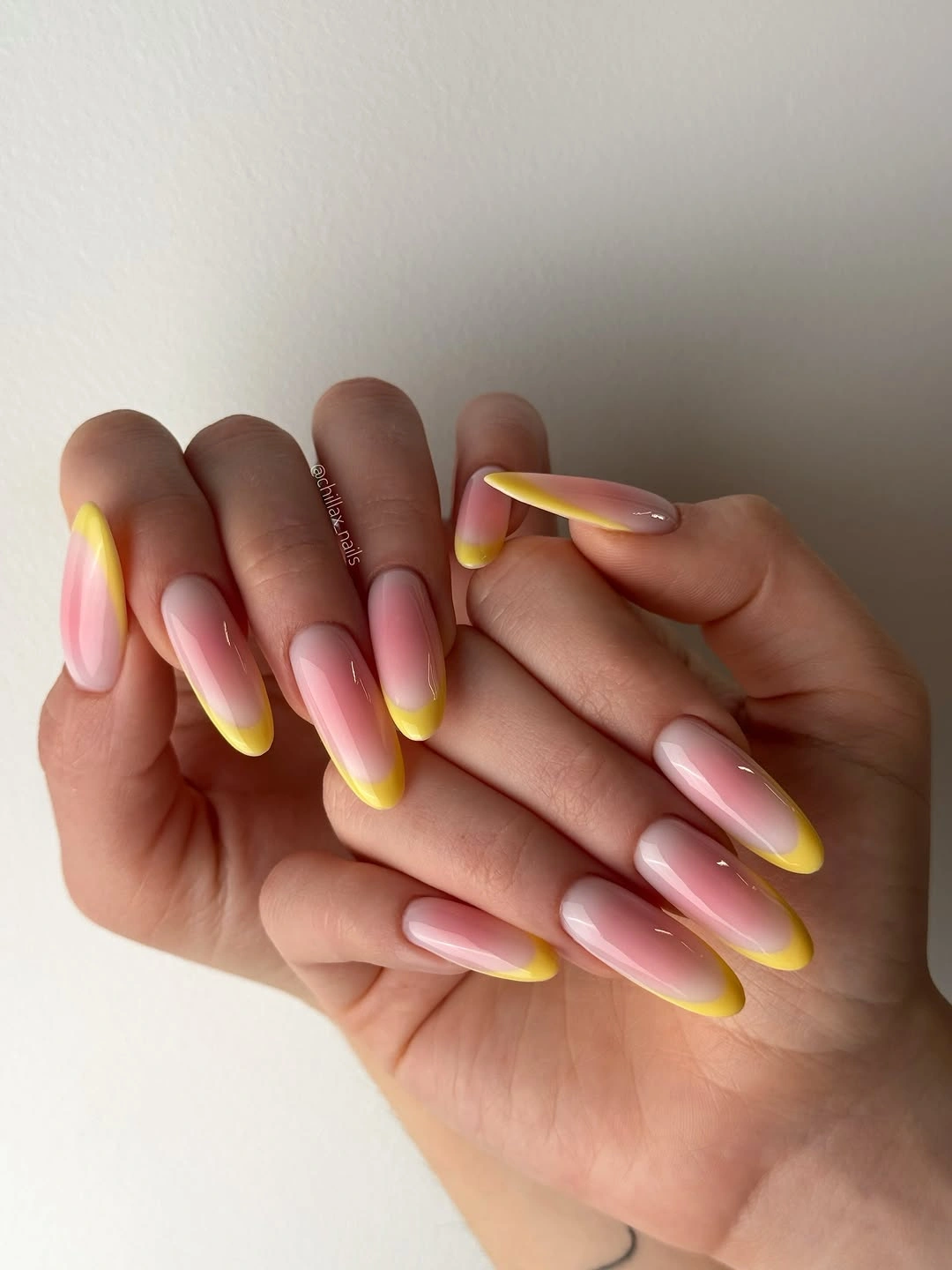 long almond pink nails with bright yellow French tips