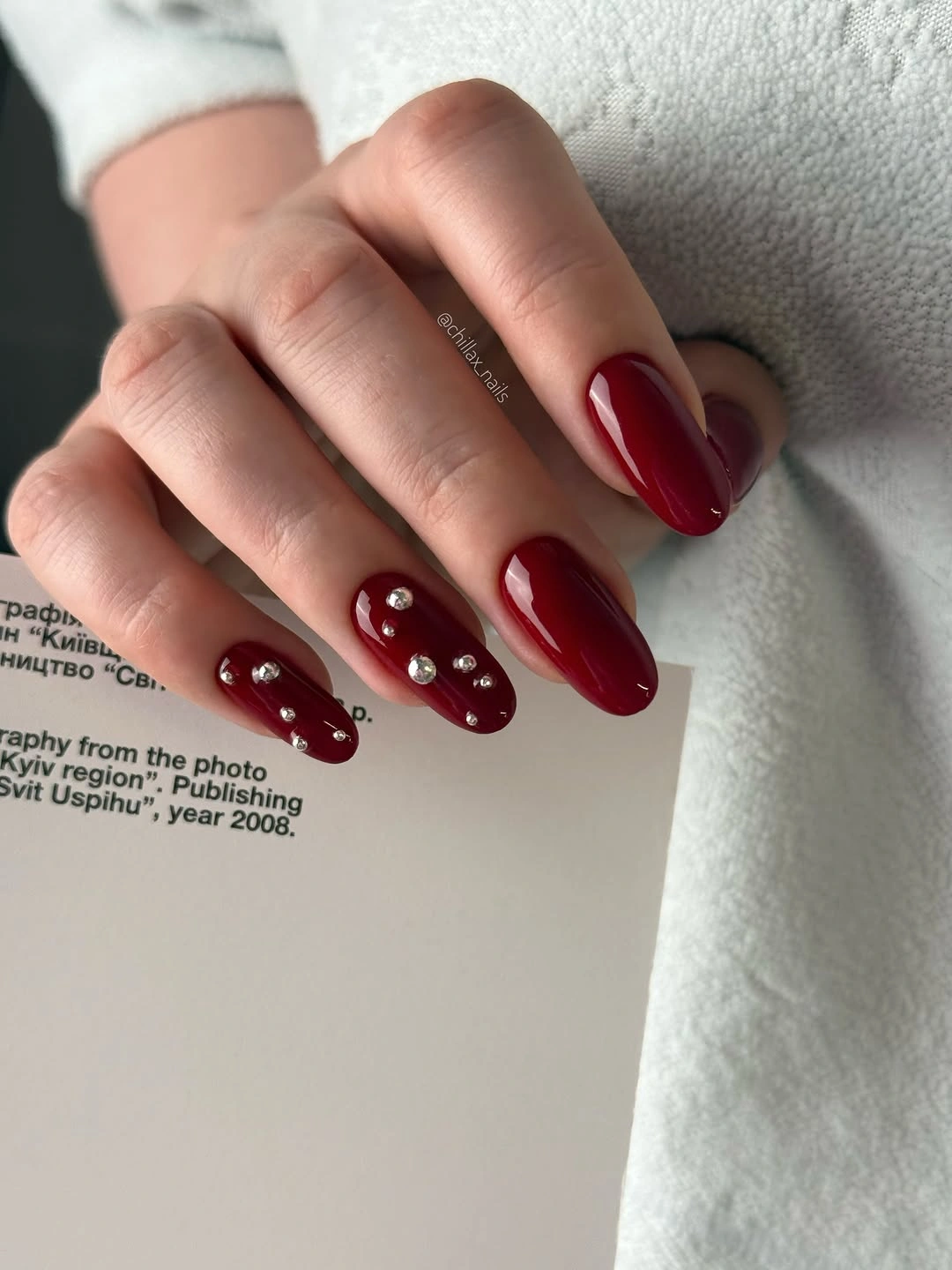 long burgundy almond nails with small light accents