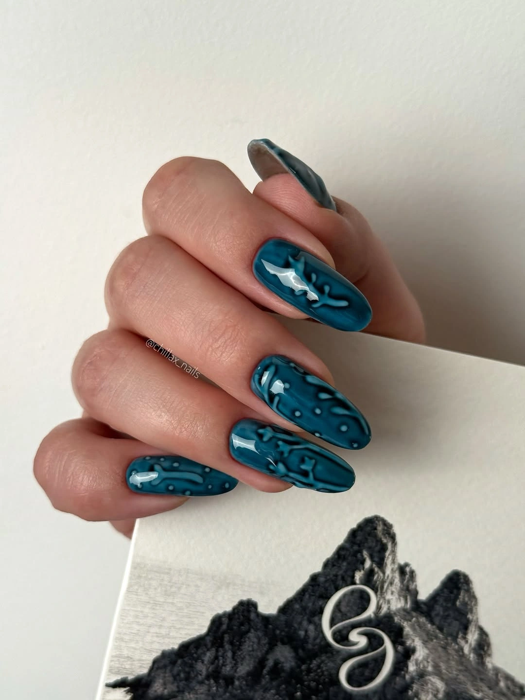 medium teal nails with raised blue abstract line work