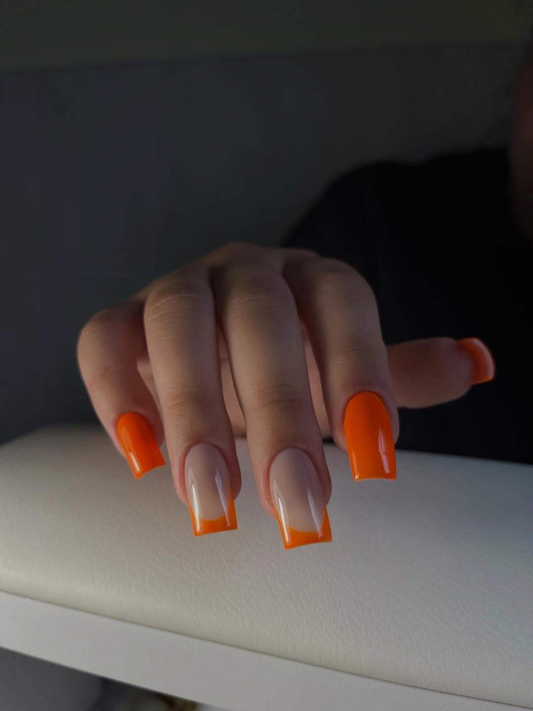 medium square nails with neon orange tips and fine inner lines