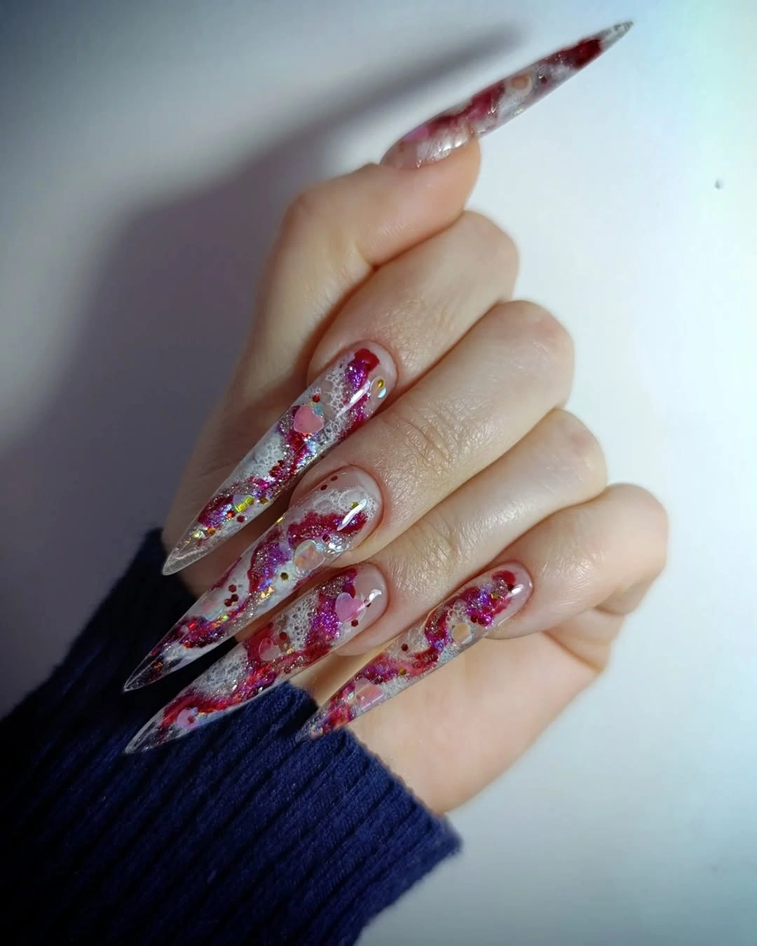 White oval nails with orange tips and tiny dots