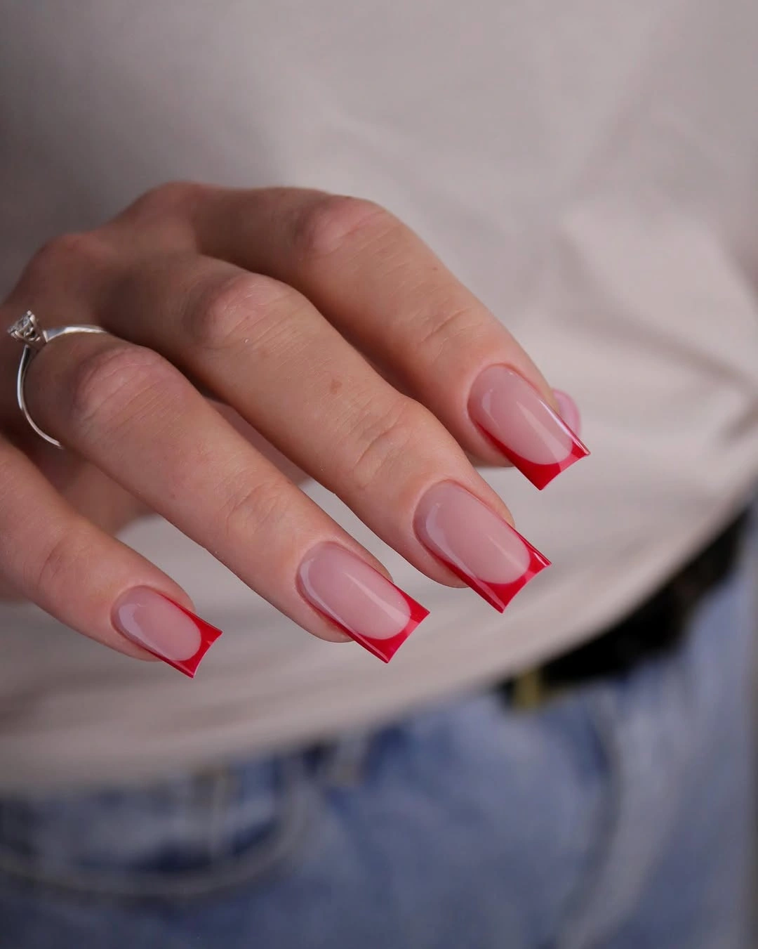 Nude square nails with crisp vivid red French tips