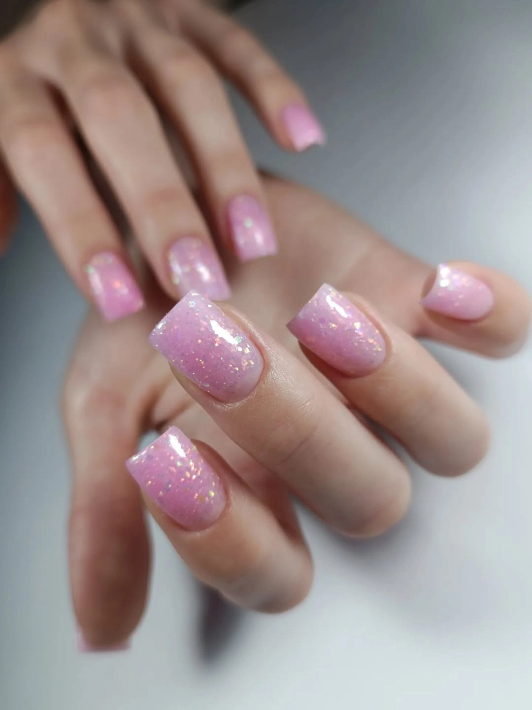 Sheer pink square nails with curved red edge accents