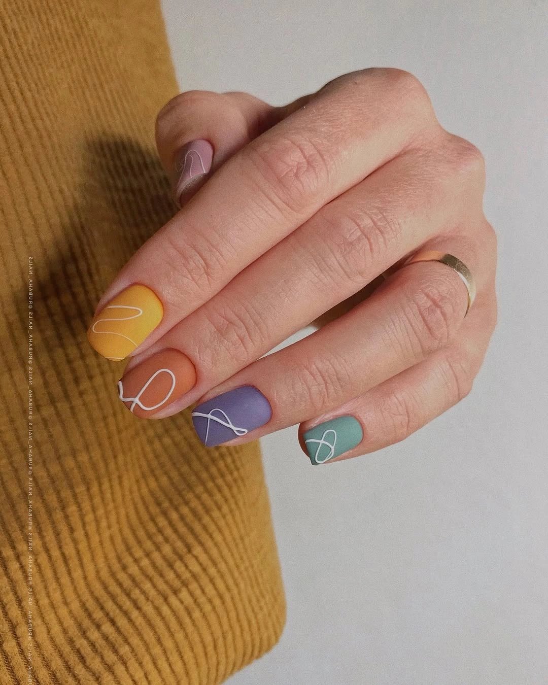 muted multicolor short nails with white line art