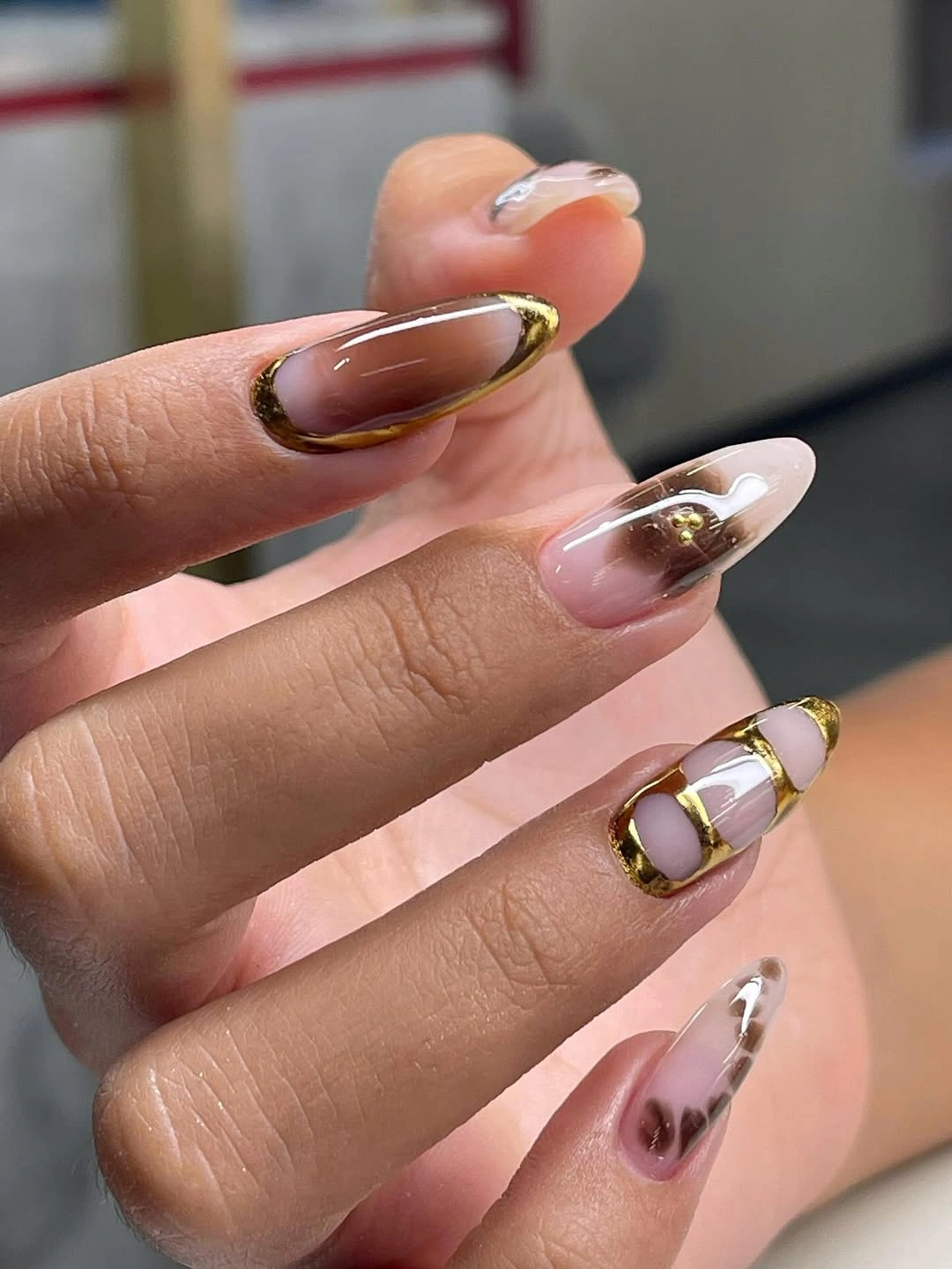 transparent brown almond nails with gold outlines