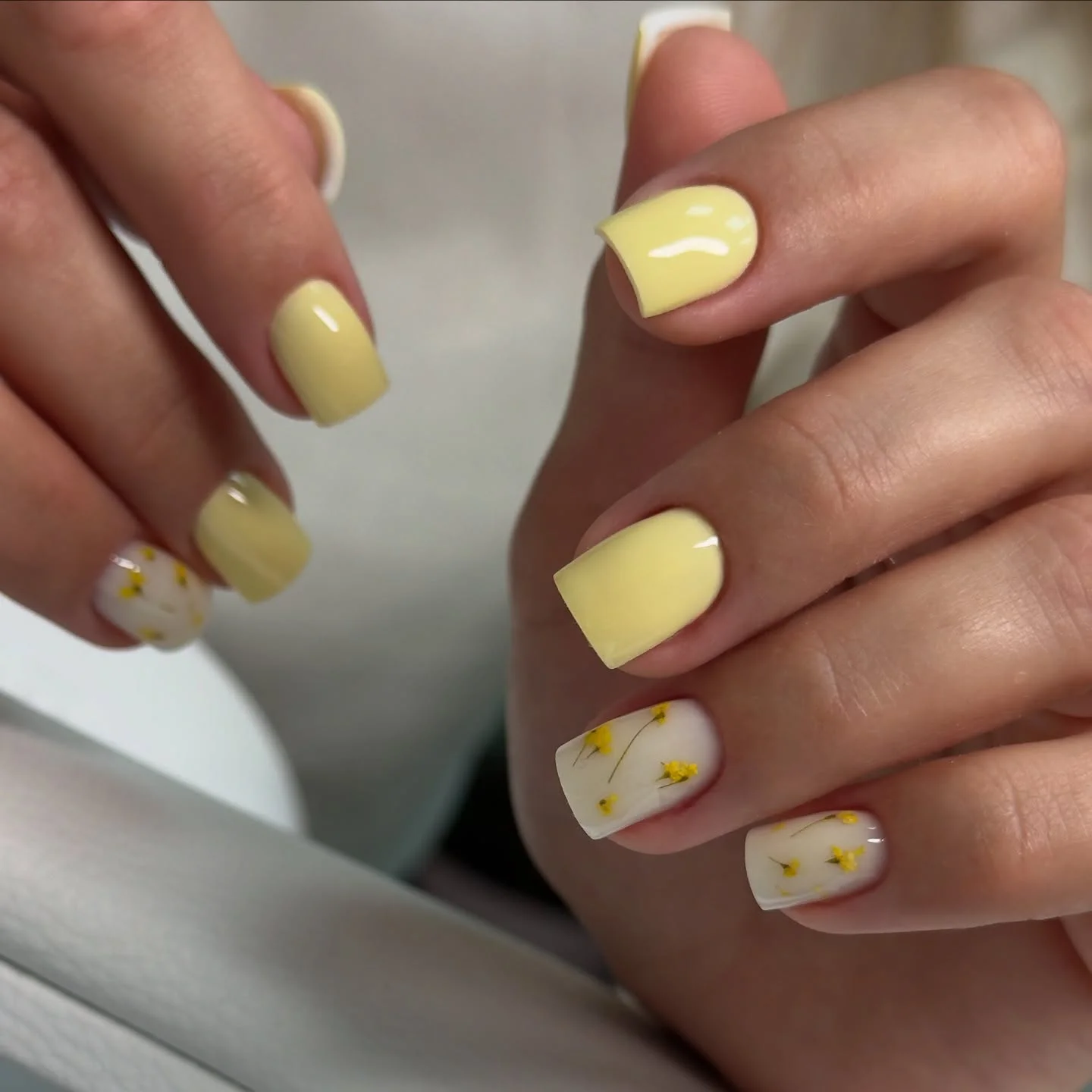 short yellow nails with white floral accents