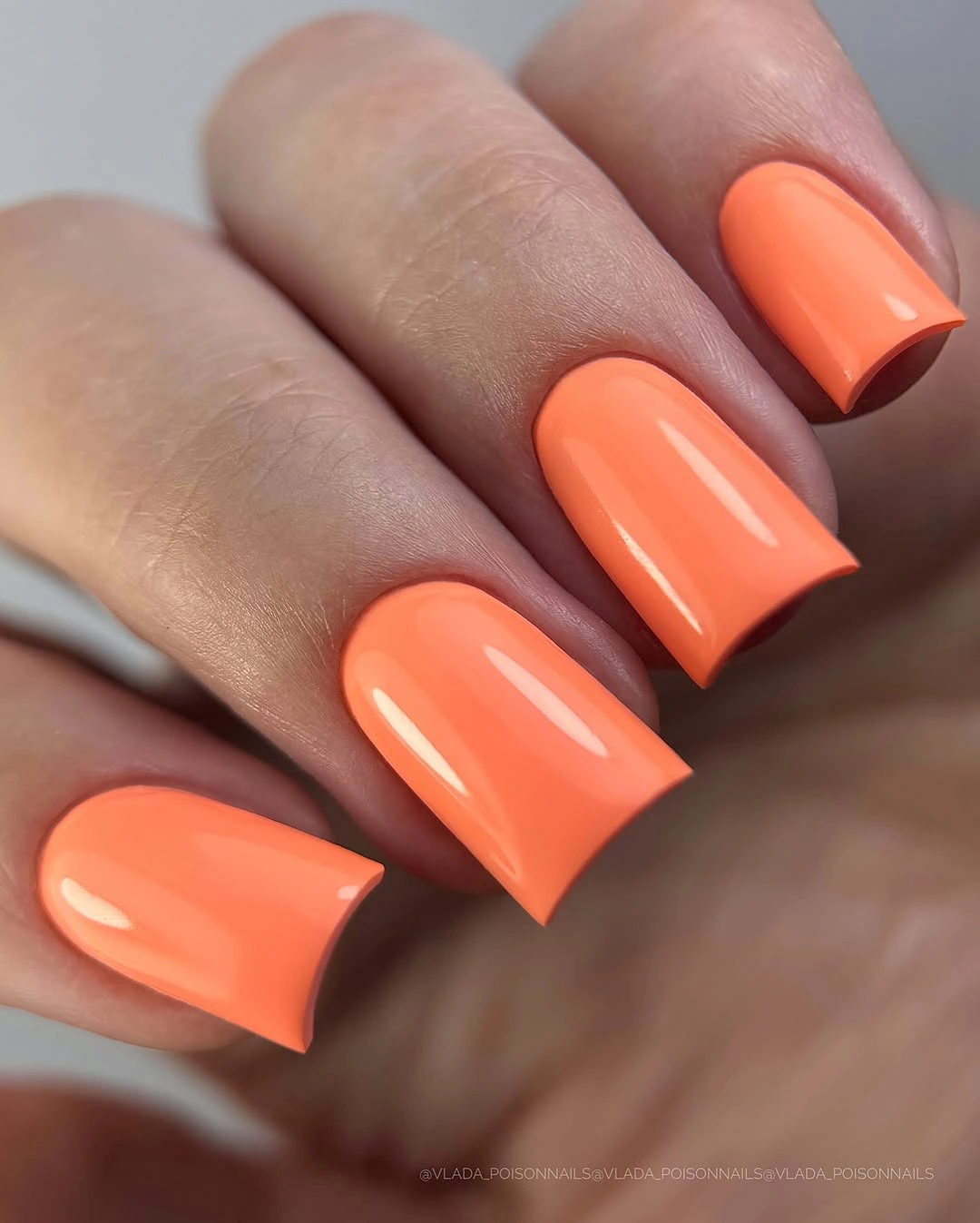 bright coral medium-square nails with a glossy finish