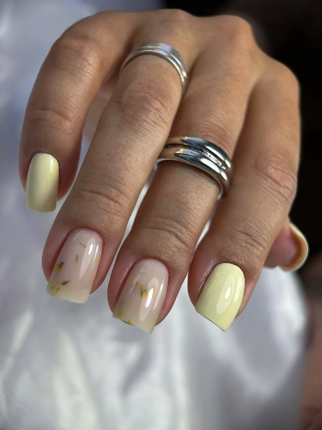creamy yellow nails with small purple and green details