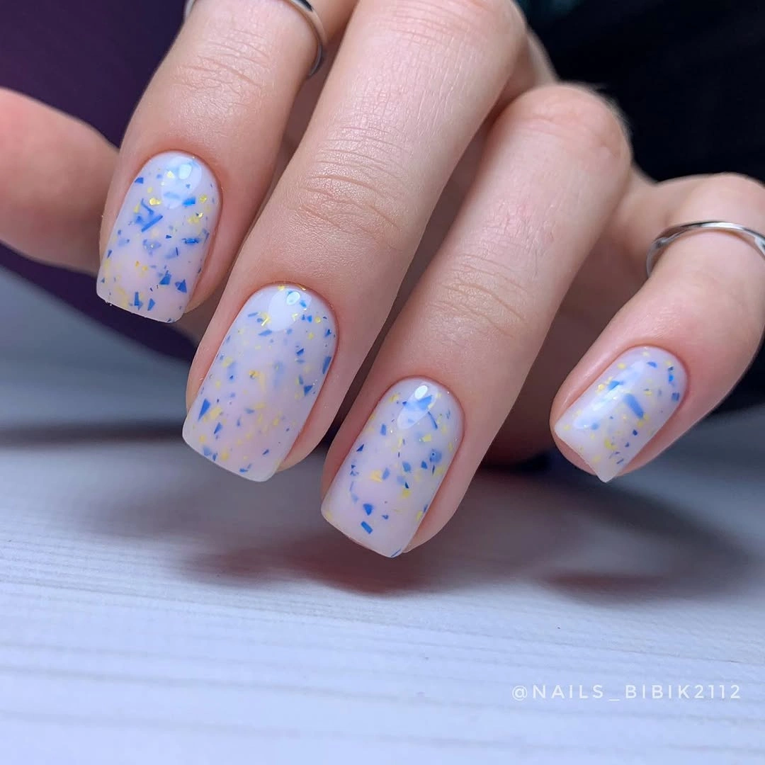 short lavender nails scattered with blue and purple speckles