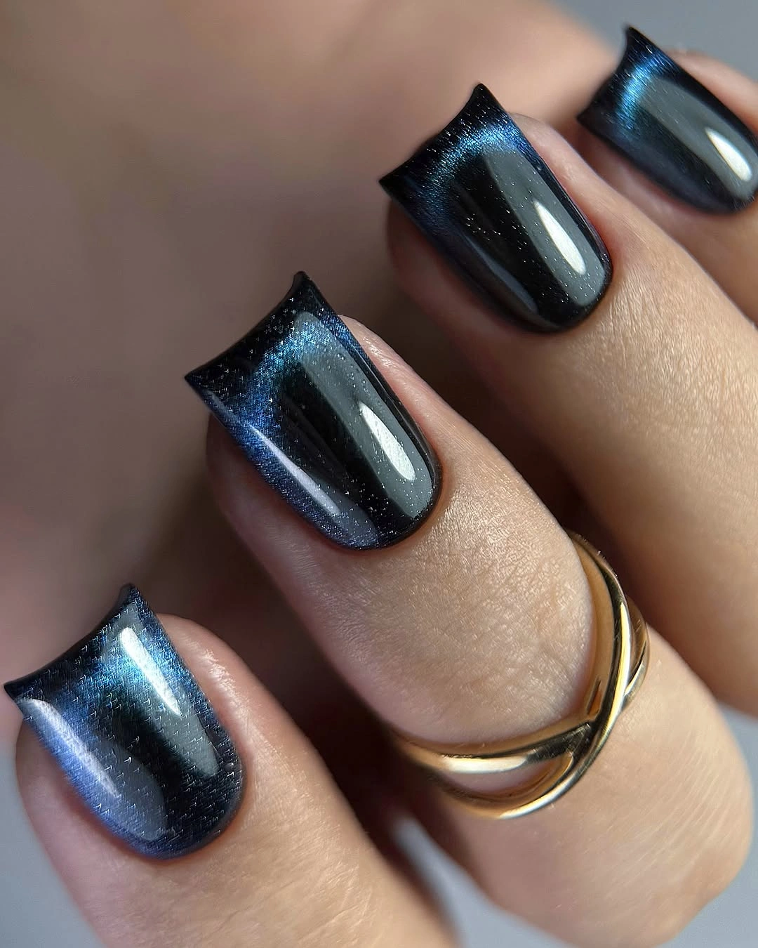 dark navy nails with a reflective blue metallic finish